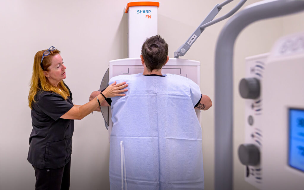 X-ray tech with patient standing for an x-ray